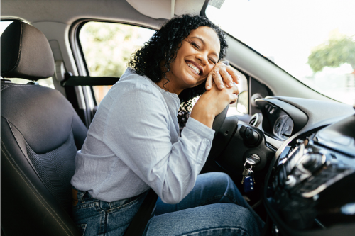 Member smiling inside a car